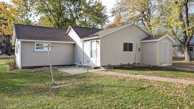 back of house featuring a lawn and a patio area