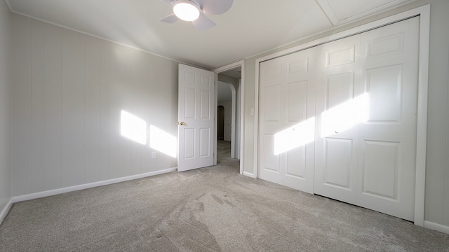 unfurnished bedroom featuring ceiling fan, a closet, and light carpet