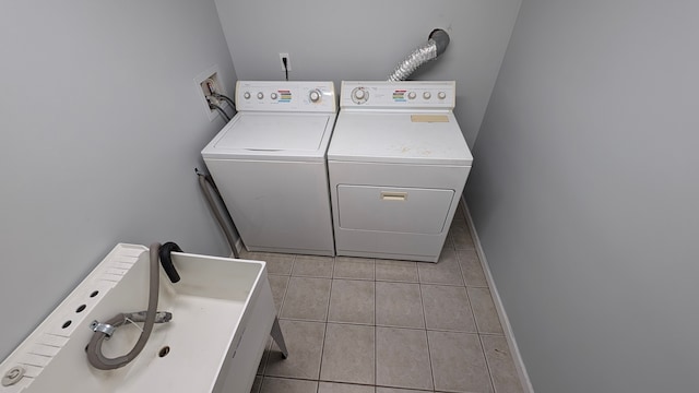 washroom with light tile patterned floors and washing machine and dryer