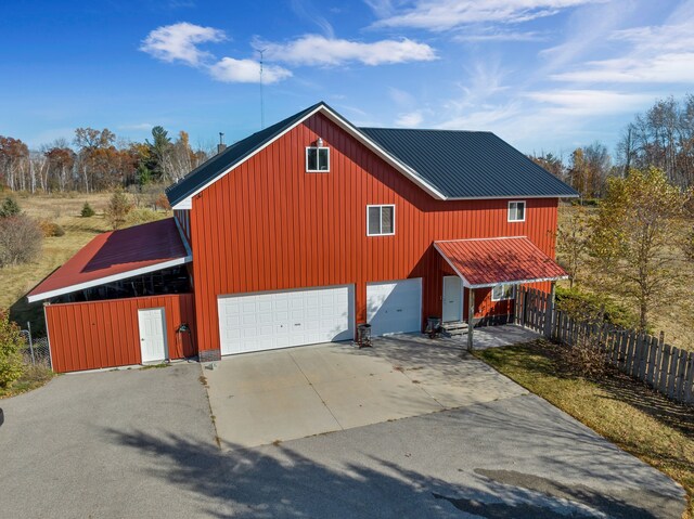 381 S Lorenz Rd, Tawas City, MI 48763 - view of front facade with driveway, a garage, and metal roof