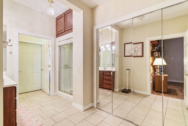 bathroom with tile patterned floors, a shower with door, and vanity