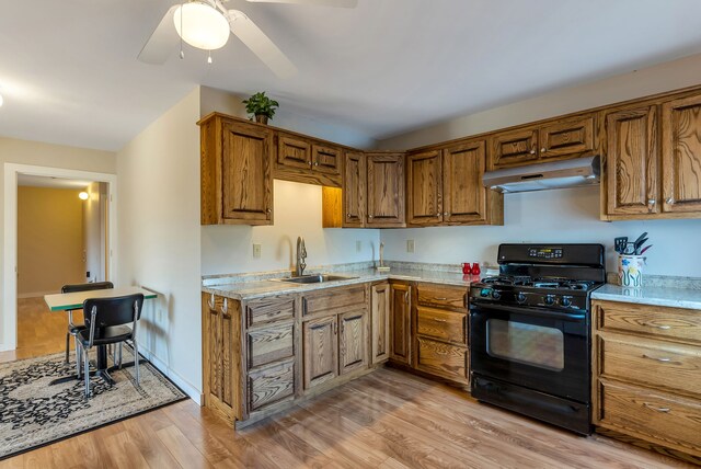 381 S Lorenz Rd, Tawas City, MI 48763 - kitchen featuring gas stove, a sink, under cabinet range hood, and brown cabinetry