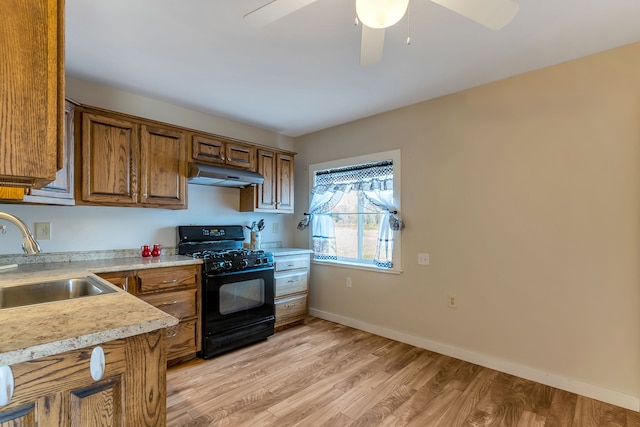 kitchen featuring ceiling fan, light hardwood / wood-style floors, black gas stove, and sink