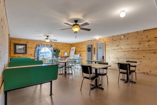 381 S Lorenz Rd, Tawas City, MI 48763 - dining area featuring wood walls and ceiling fan