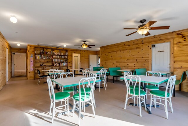 381 S Lorenz Rd, Tawas City, MI 48763 - dining room with a ceiling fan and wood walls