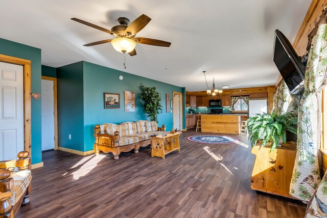 381 S Lorenz Rd, Tawas City, MI 48763 - living area with ceiling fan, a chandelier, dark wood-style floors, and baseboards