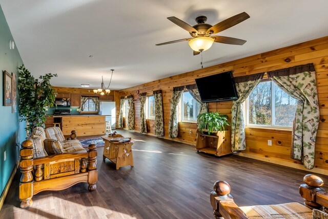381 S Lorenz Rd, Tawas City, MI 48763 - living room with a chandelier, dark wood-type flooring, wood walls, and ceiling fan
