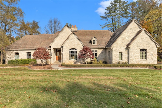 french country style house with a front yard