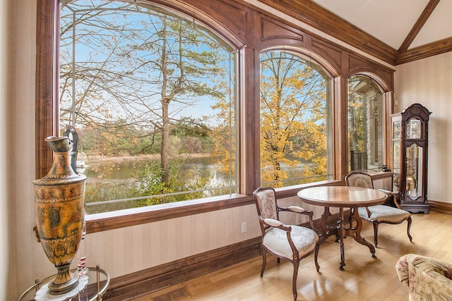 sunroom / solarium featuring a water view and lofted ceiling