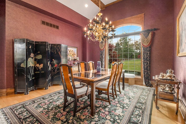 dining area with light wood-type flooring and an inviting chandelier