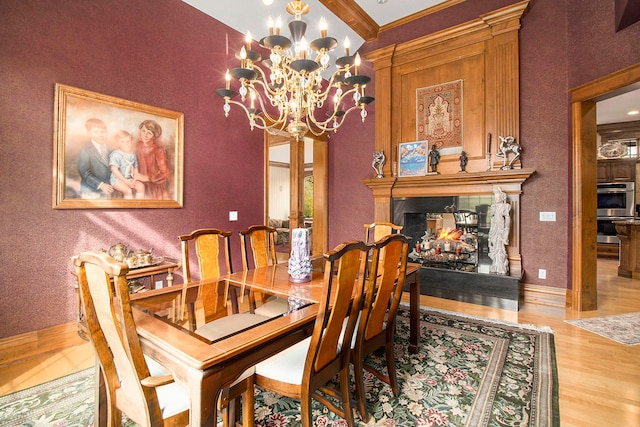 dining space with hardwood / wood-style flooring, an inviting chandelier, and ornamental molding