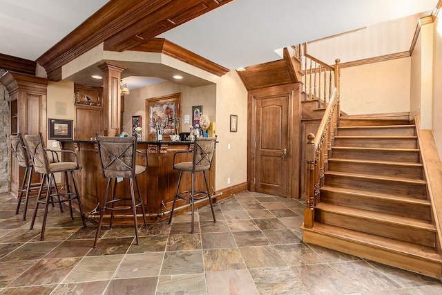 bar with crown molding and decorative columns