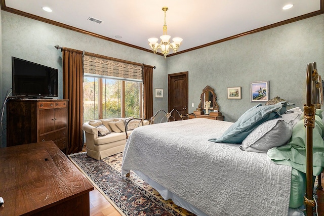 bedroom featuring ornamental molding, wood-type flooring, and an inviting chandelier