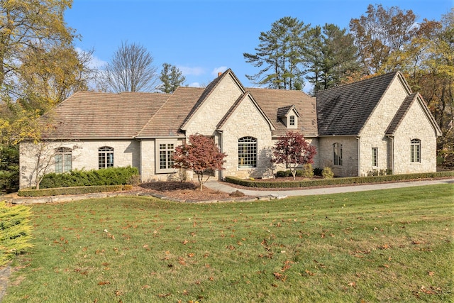 french country inspired facade with a front lawn