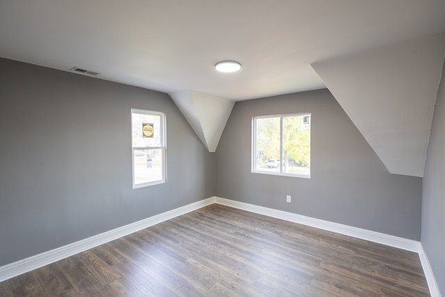 bonus room with dark hardwood / wood-style flooring and lofted ceiling