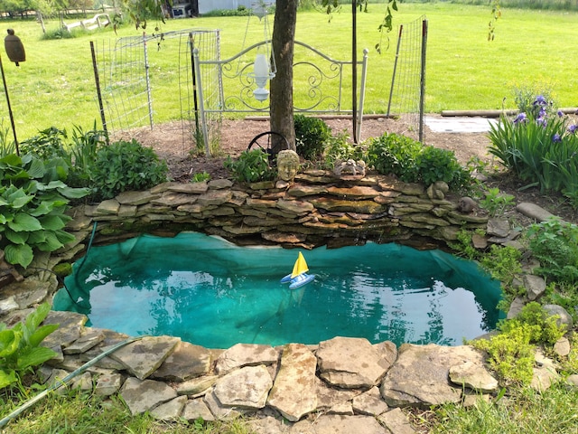 view of pool featuring a yard and a garden pond