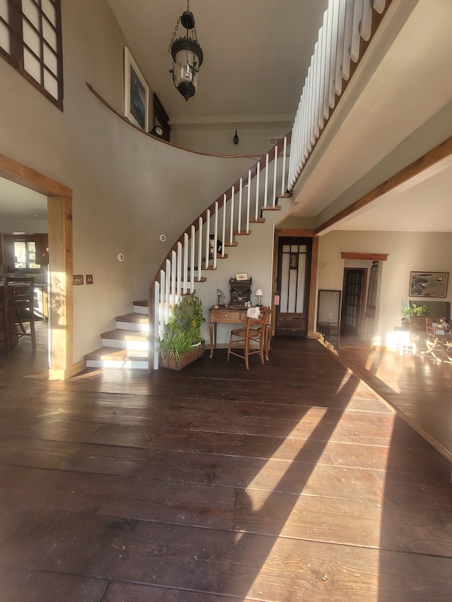 stairs featuring hardwood / wood-style flooring, a high ceiling, and an inviting chandelier