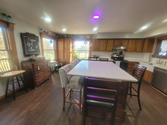 kitchen featuring backsplash, a center island, sink, stainless steel appliances, and dark hardwood / wood-style flooring