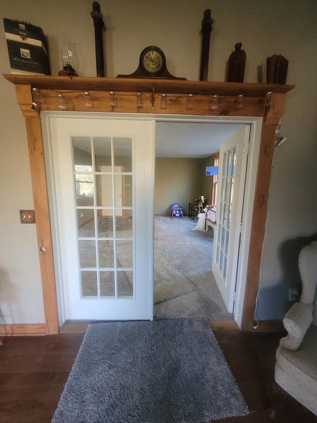 hallway featuring dark carpet and french doors