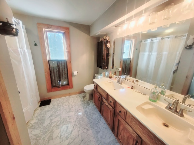 bathroom featuring plenty of natural light, toilet, and vanity