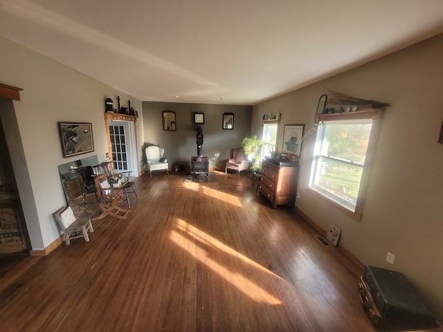 unfurnished living room with dark hardwood / wood-style flooring and a wood stove