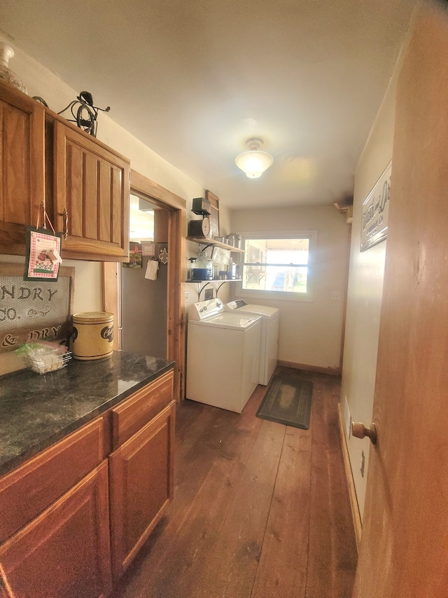 washroom with washing machine and dryer, dark wood-type flooring, and cabinets