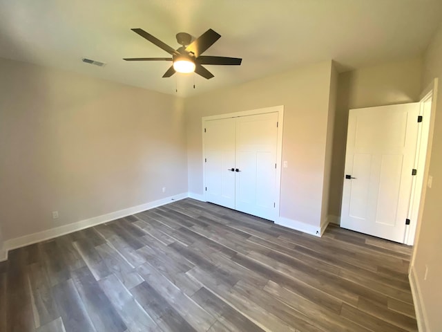 unfurnished bedroom featuring dark hardwood / wood-style flooring, a closet, and ceiling fan