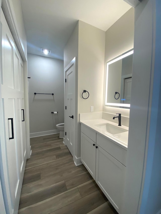 bathroom featuring hardwood / wood-style flooring, vanity, and toilet