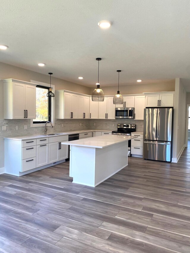 7480/7482 Head Rd, Delton, MI 49046 - kitchen with appliances with stainless steel finishes, a sink, white cabinetry, light countertops, and recessed lighting