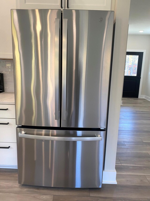 7480/7482 Head Rd, Delton, MI 49046 - kitchen view of freestanding refrigerator, white cabinets, wood finished floors, and light countertops
