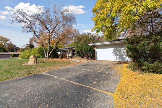 ranch-style house featuring a garage and a front lawn