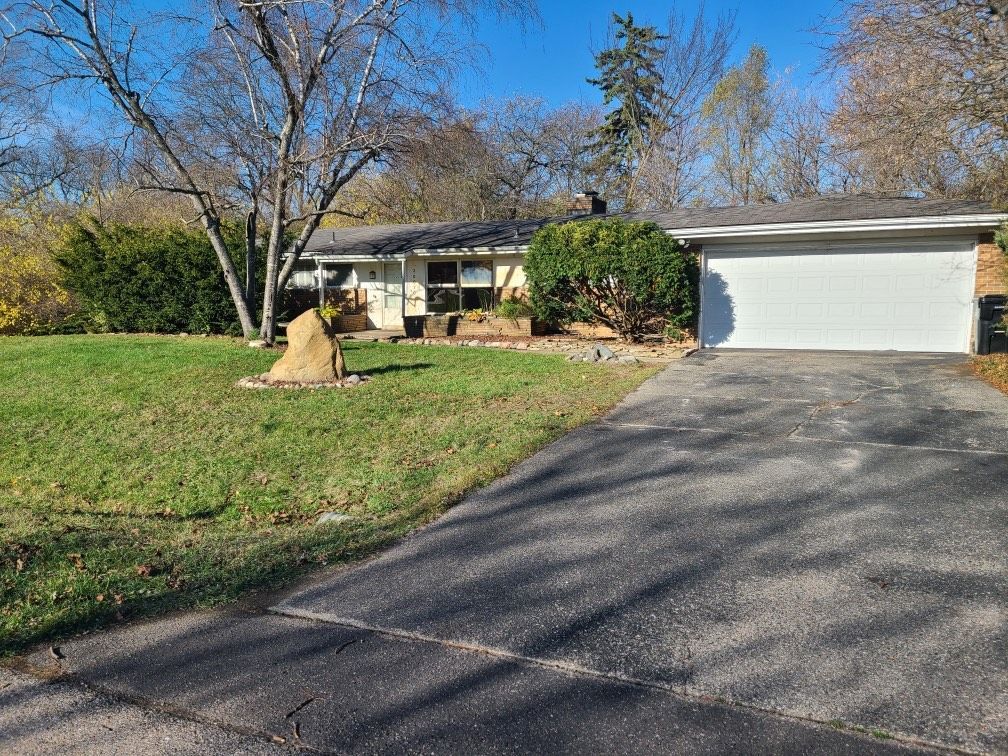 single story home with a garage and a front lawn