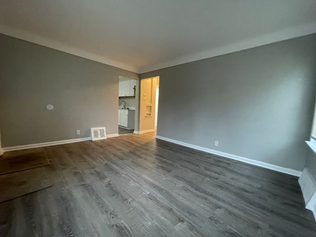 spare room featuring sink and wood-type flooring