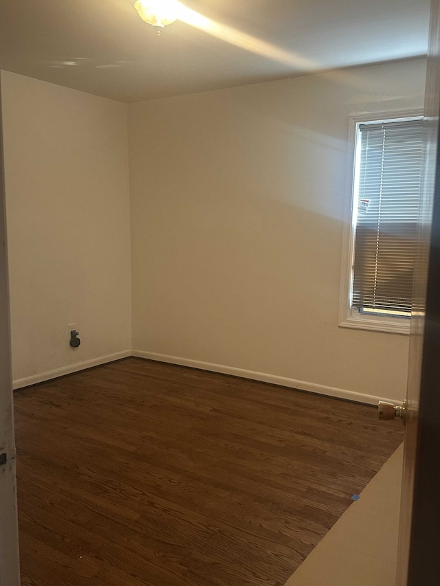 spare room with dark hardwood / wood-style flooring