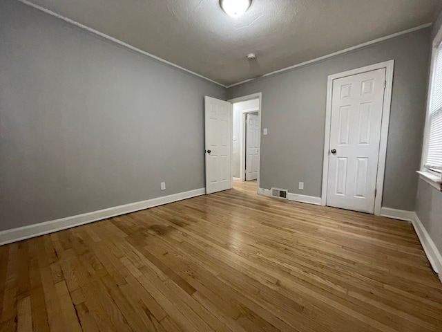 unfurnished bedroom featuring light hardwood / wood-style floors and ornamental molding