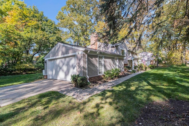 view of home's exterior with a garage and a yard