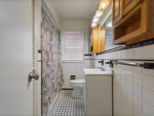 bathroom with vanity, tile walls, and toilet