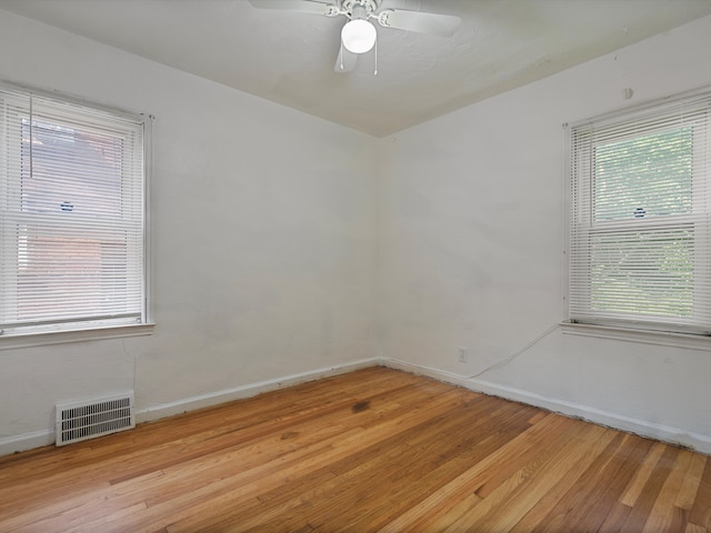 spare room with plenty of natural light, ceiling fan, and light wood-type flooring