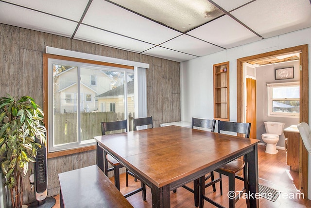 dining area featuring hardwood / wood-style floors and wooden walls