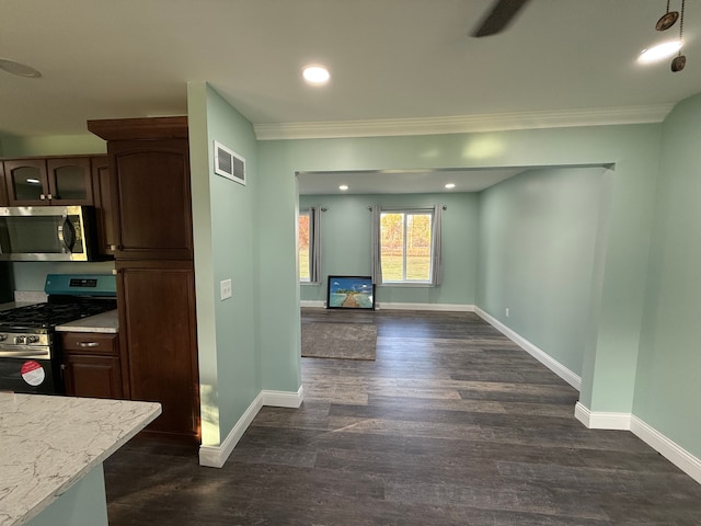 kitchen featuring dark brown cabinetry, dark hardwood / wood-style flooring, stainless steel appliances, and ornamental molding