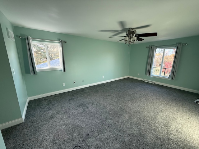 carpeted empty room with ceiling fan and a wealth of natural light