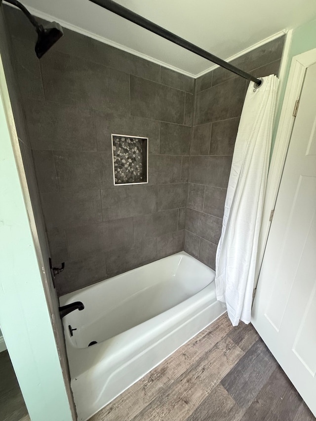 bathroom featuring wood-type flooring and shower / tub combo