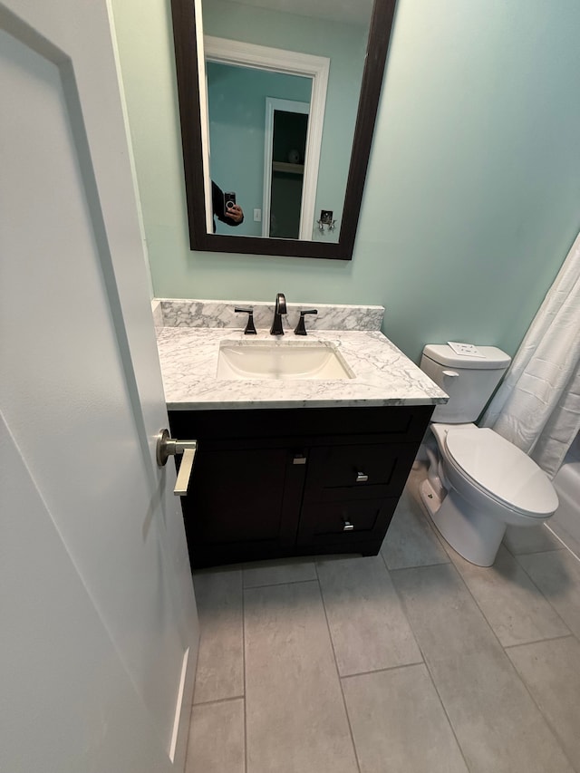 bathroom featuring tile patterned flooring, vanity, and toilet