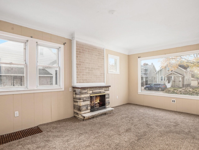 unfurnished living room with carpet, a fireplace, and ornamental molding