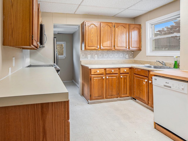 kitchen with a paneled ceiling, dishwasher, and sink