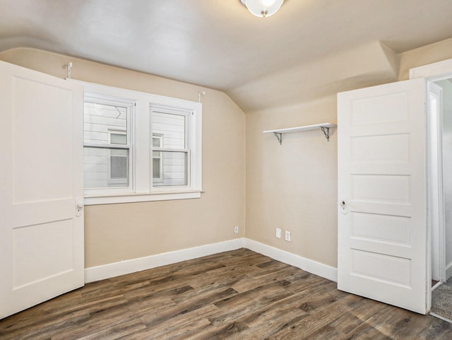 interior space featuring dark hardwood / wood-style flooring and lofted ceiling