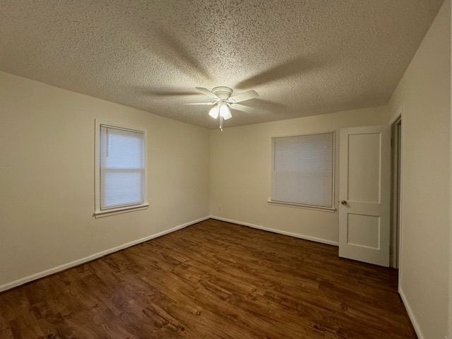 spare room featuring dark hardwood / wood-style floors, a textured ceiling, and ceiling fan