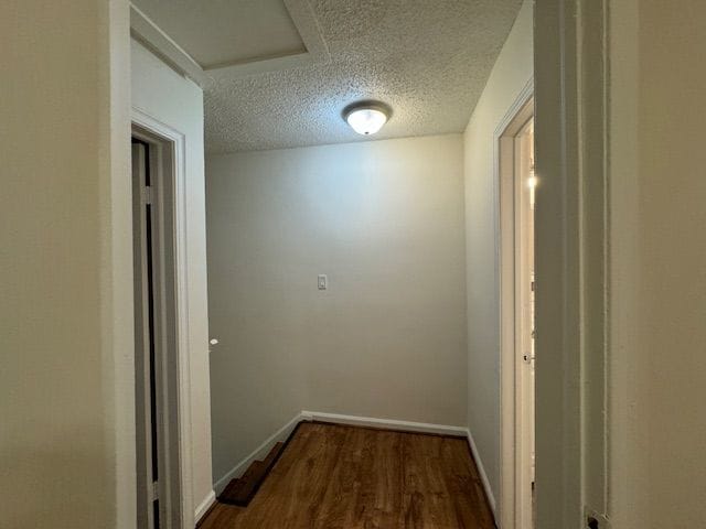 hall featuring dark hardwood / wood-style floors and a textured ceiling