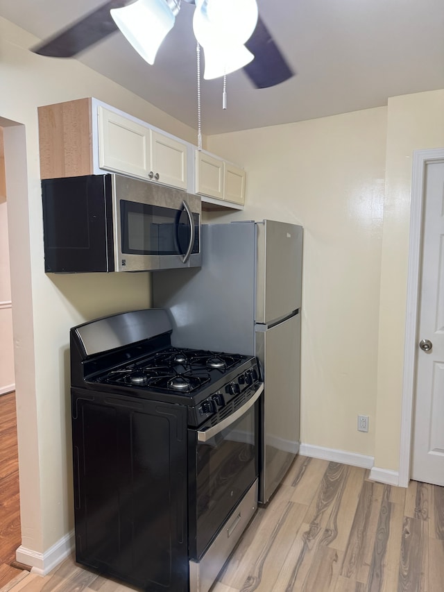 kitchen featuring ceiling fan, stainless steel appliances, light hardwood / wood-style floors, and white cabinets