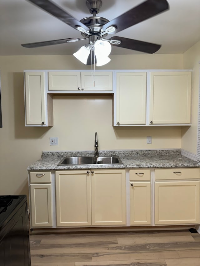 kitchen featuring sink, light hardwood / wood-style floors, and light stone countertops